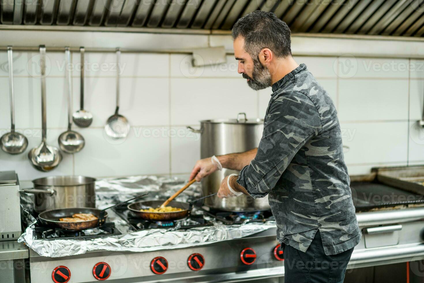 een chef is voorbereidingen treffen een maaltijd in de restaurants keuken. foto