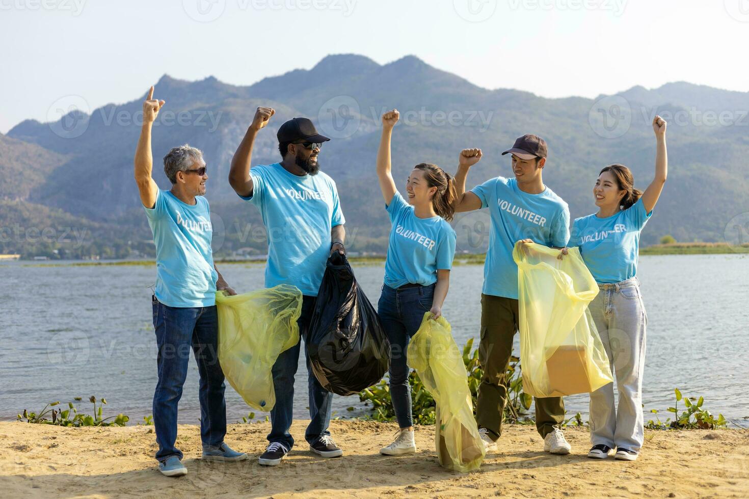team van jong en verscheidenheid vrijwilliger arbeider groep genieten liefdadigheid sociaal werk buitenshuis in schoonmaak omhoog vuilnis en verspilling scheiding project Bij de rivier- strand foto