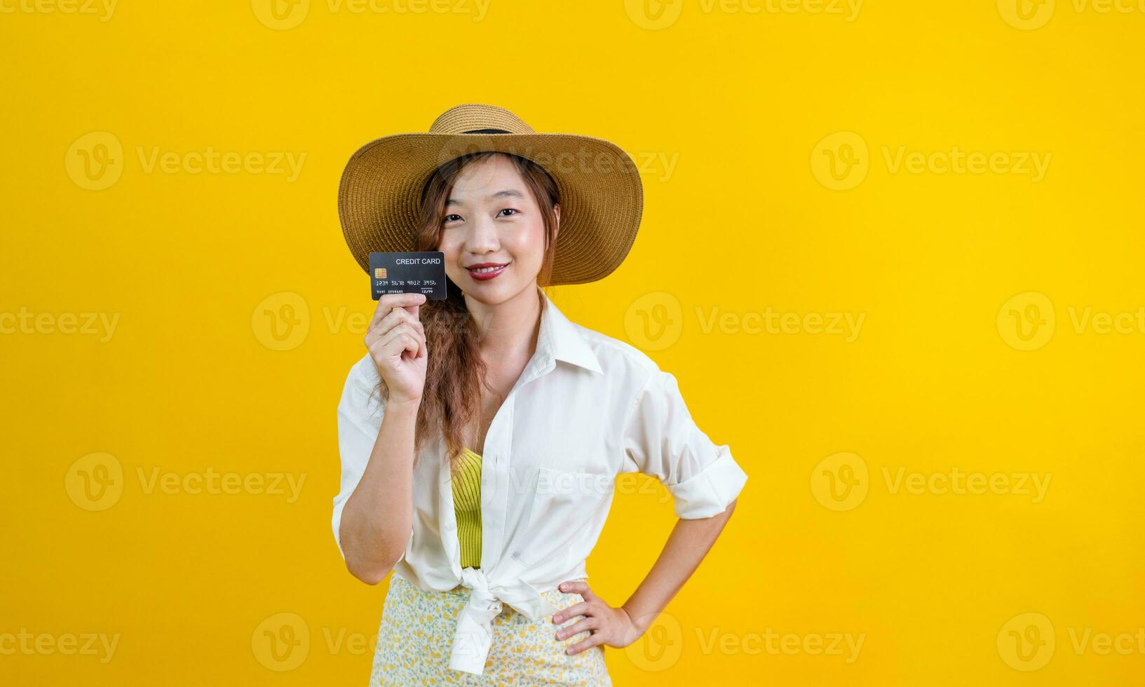 portret van jong Aziatisch vrouw in gewoontjes strand kleding met credit kaart is tonen uitverkoop Promotie geïsoleerd Aan geel achtergrond voor reizen en mode studio besnoeiing uit concept foto