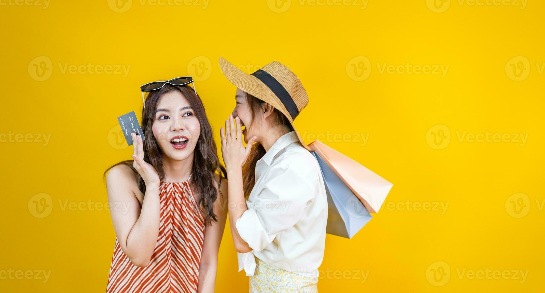 portret van jong Aziatisch vrouw in gewoontjes strand kleding met credit kaart is vertellen haar vriend over uitverkoop Promotie geïsoleerd Aan geel achtergrond voor reizen en mode studio besnoeiing uit gebruik foto