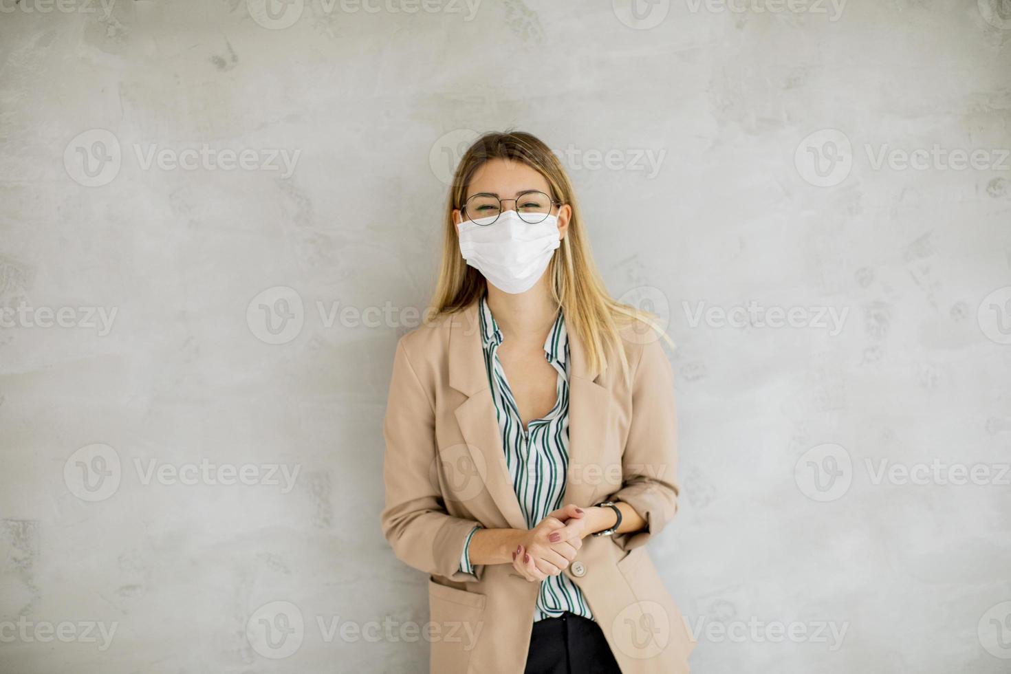 zakelijke professional tegen een grijze achtergrond met een masker foto