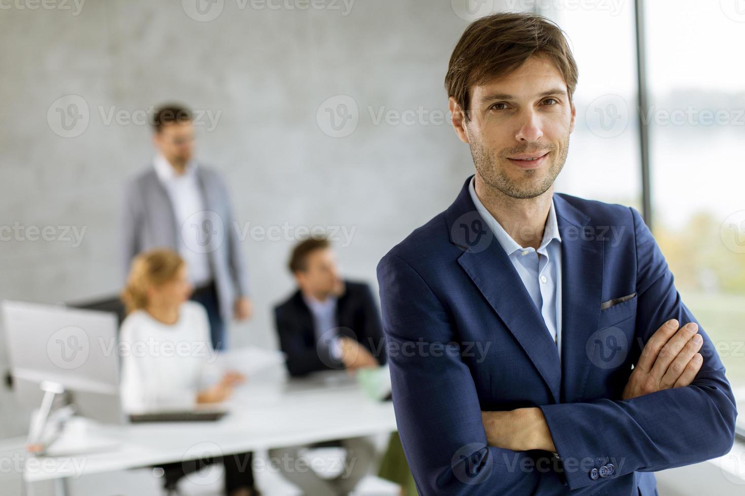 man met gekruiste armen voor team foto