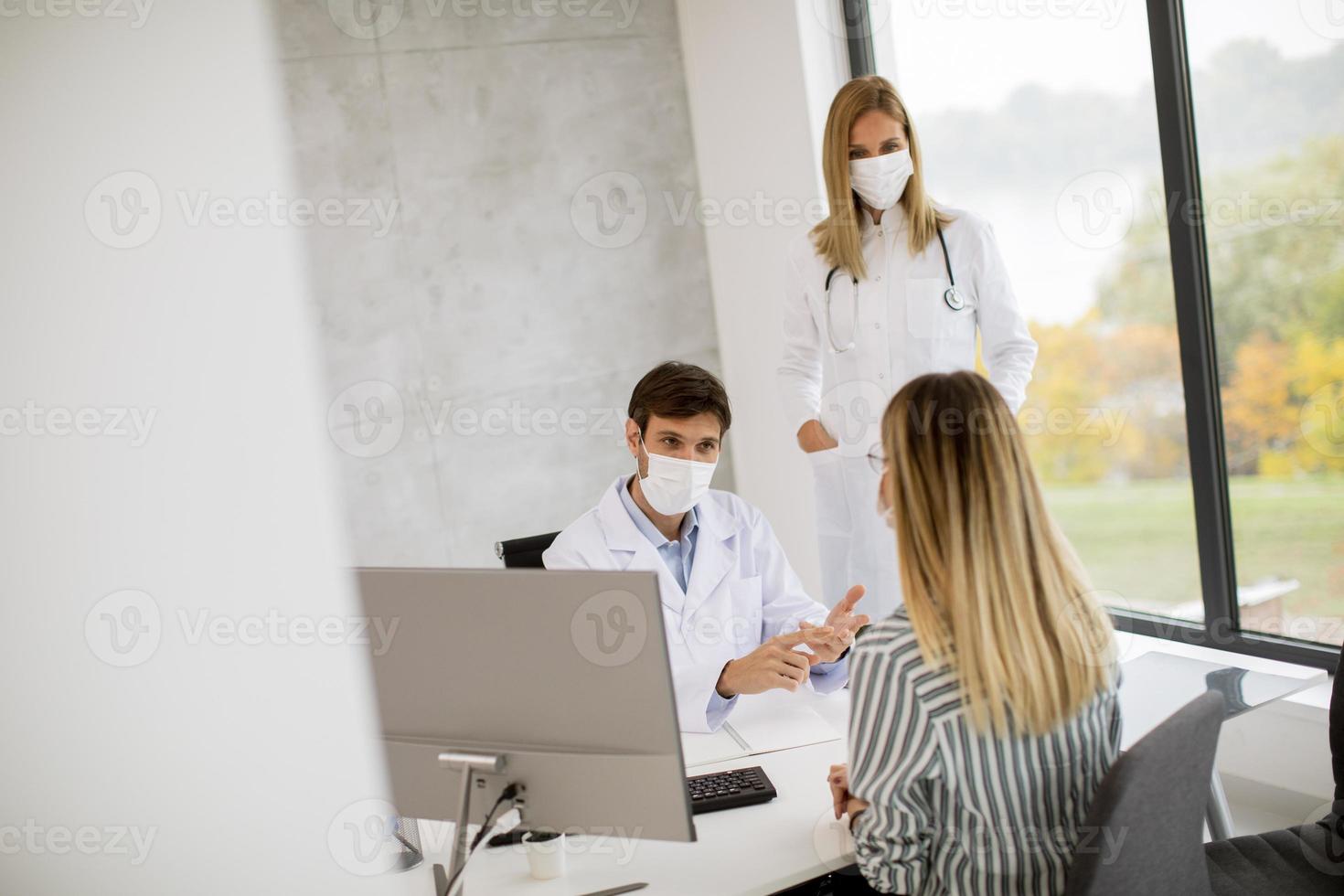 patiënt in gesprek met artsen met maskers op foto