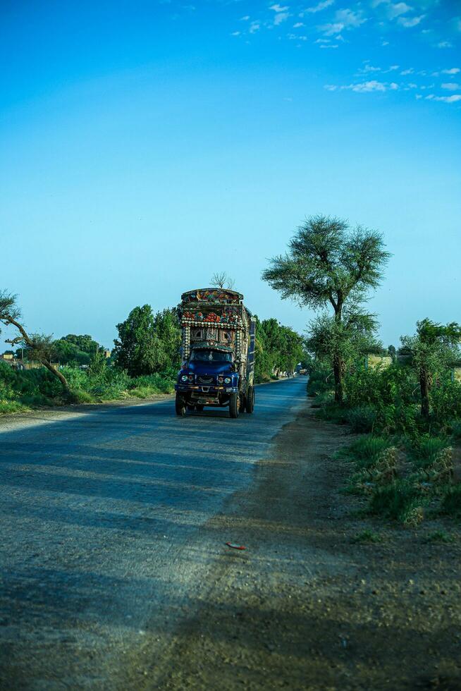 traditioneel versierd vrachtwagens Aan snelweg deze Pakistaans vrachtwagens zijn wereld beroemd voor hun kunstwerk. foto