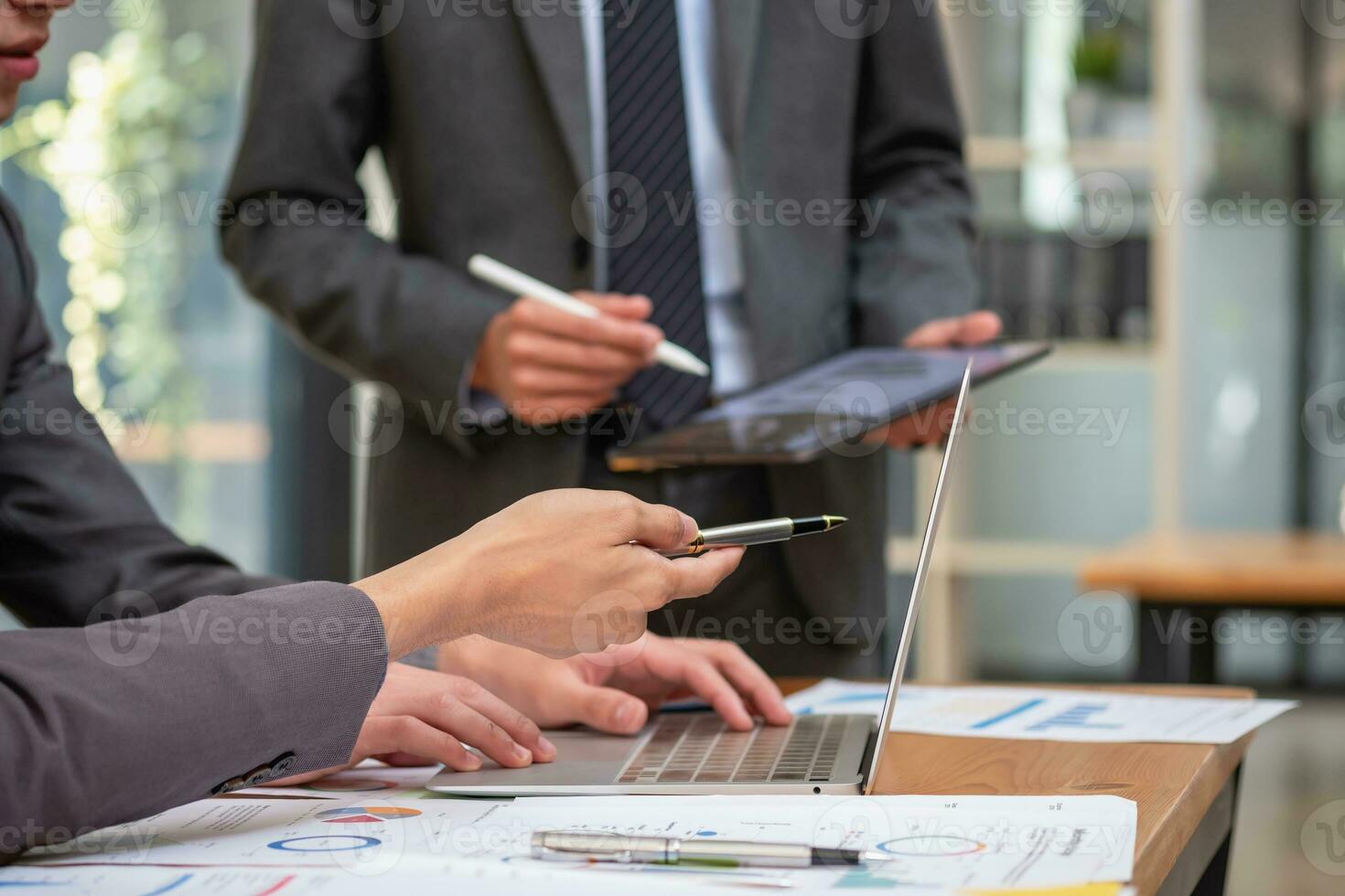 Aziatisch bedrijf team bestaat van afzet personeel. accountant en financieel officier helpen elk andere analyseren bedrijf winsten gebruik makend van tabletten. rekenmachine laptop computers, diagram papier, en zakelijke pennen. foto