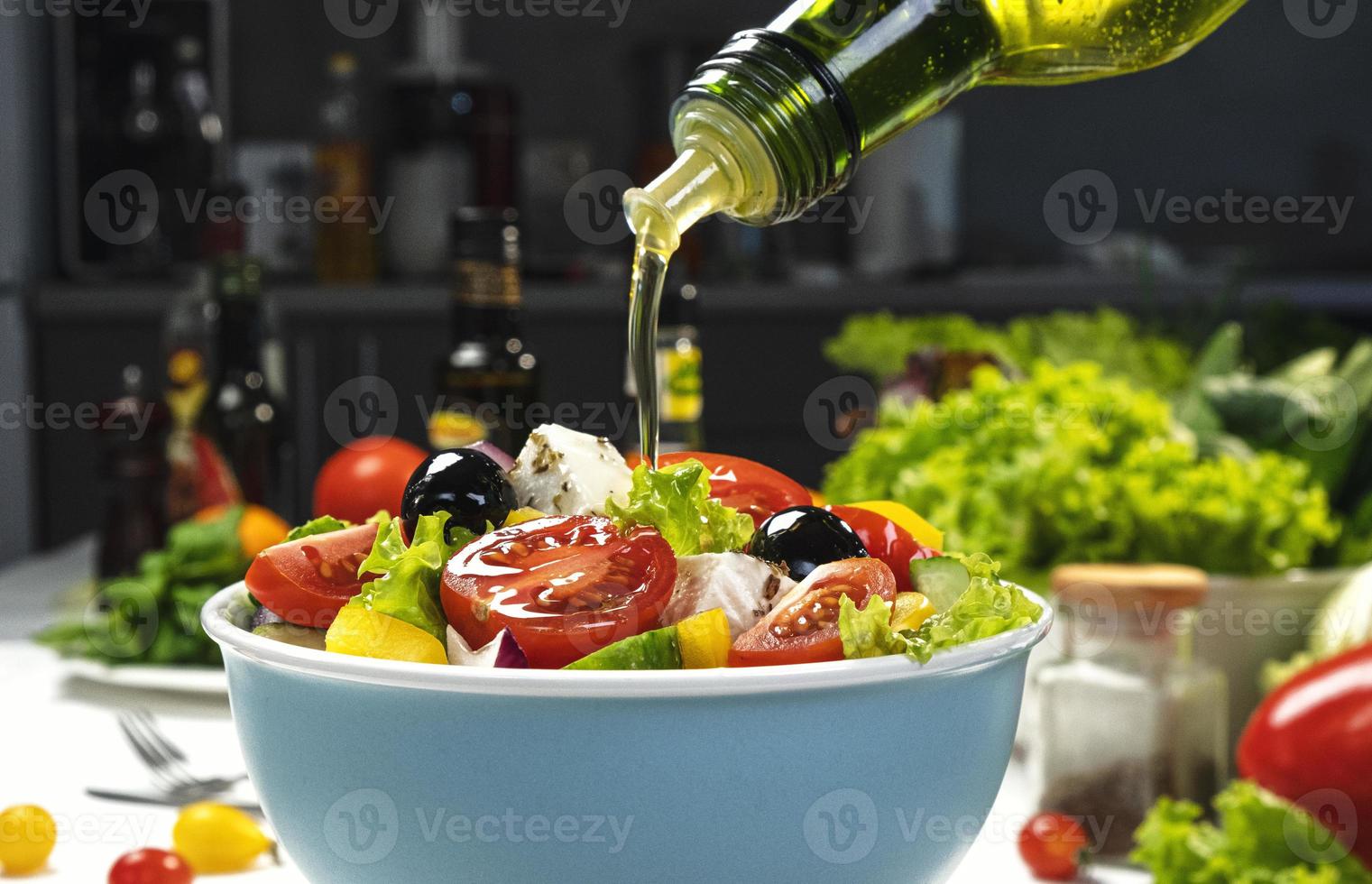 gieten olijfolie op verse groentesalade foto