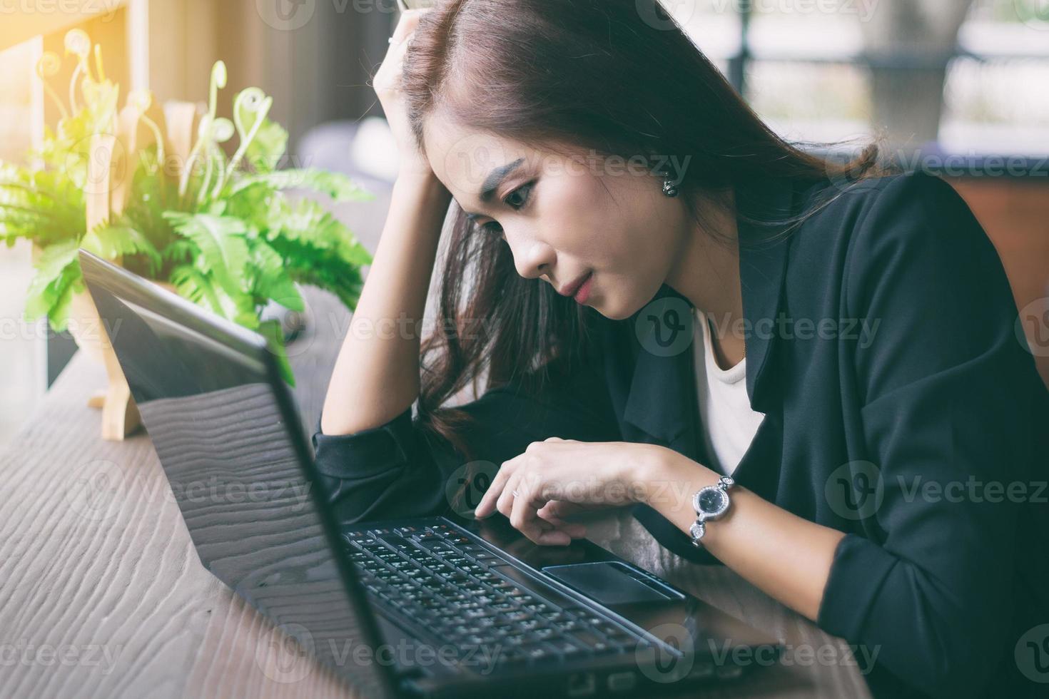 Aziatische zakenvrouw die op laptop werkt foto