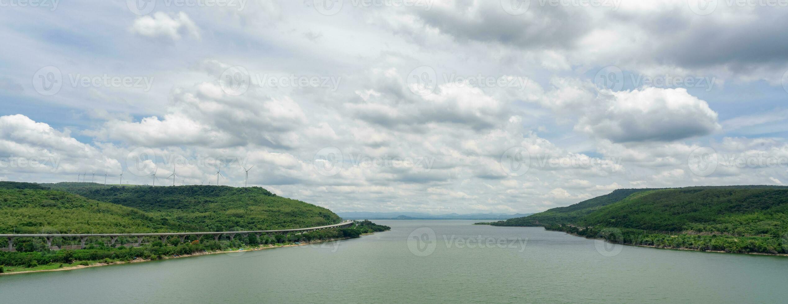 landschap groen berg met wind turbine boerderij en water reservoir met blauw lucht en wit wolken. wind energie. wind stroom. duurzaam, hernieuwbaar energie. groen technologie. duurzame ontwikkeling. foto