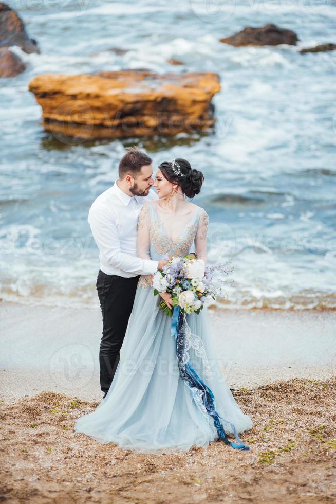 hetzelfde stel met een bruid in een blauwe jurk lopen foto