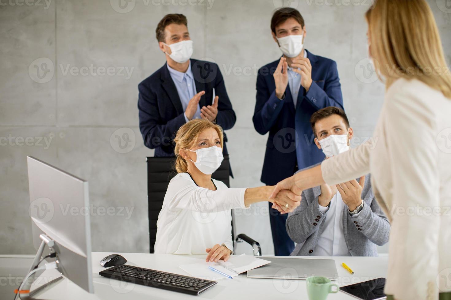 professionals handen schudden met maskers op foto