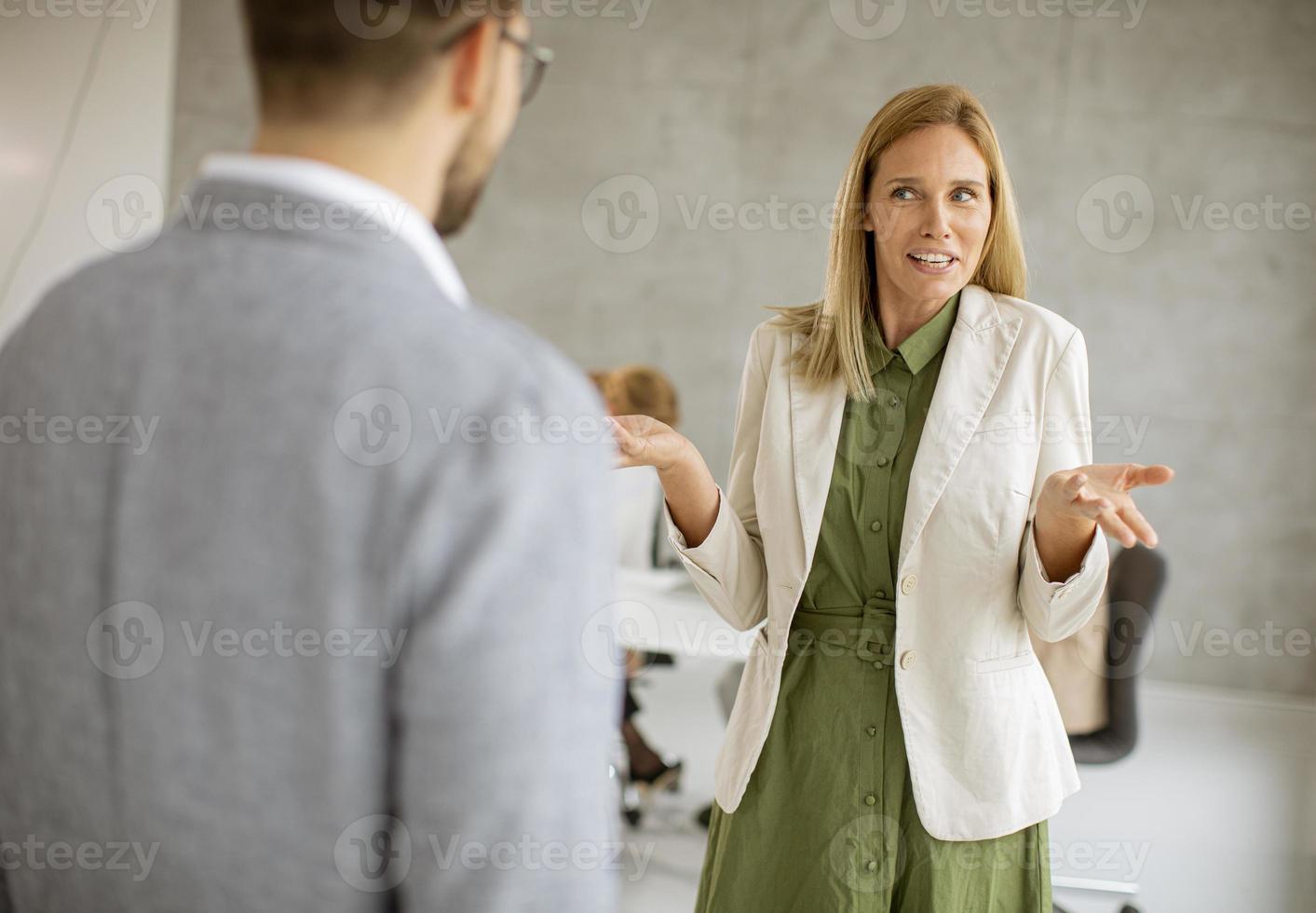 twee mensen praten in een kantoor foto
