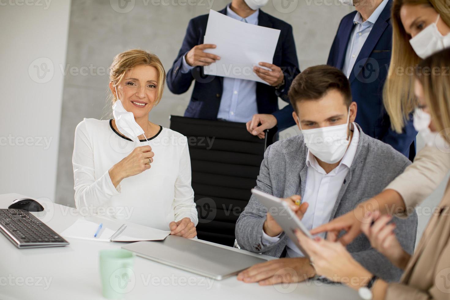 gemaskerde professionals kijken naar tablet foto