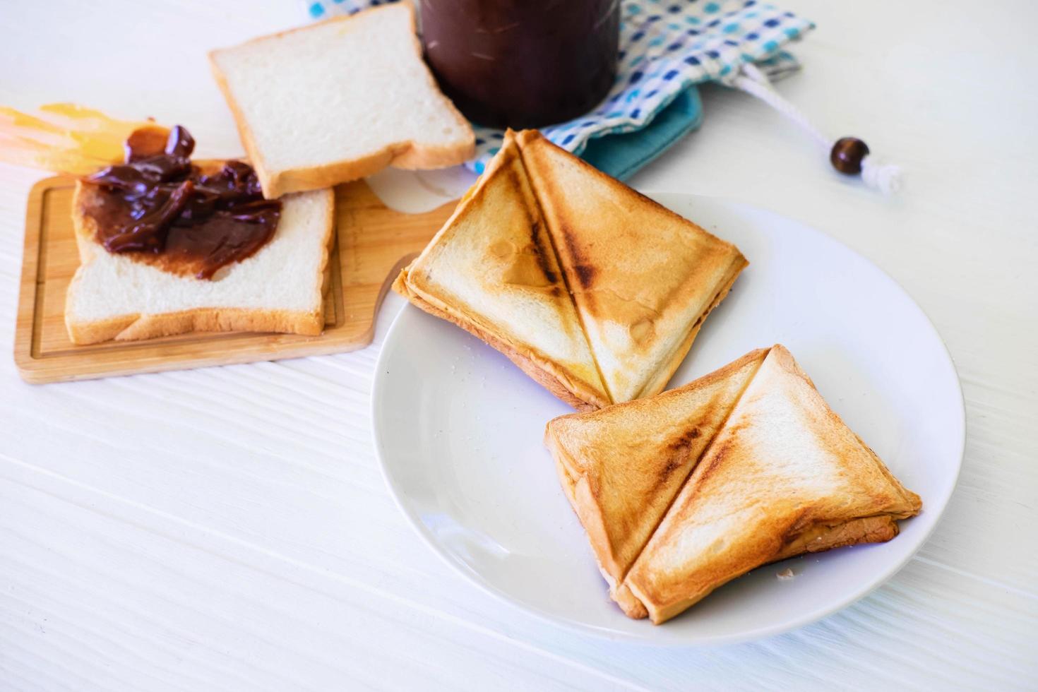 geroosterd toastbrood dat opduikt uit een roestvrijstalen broodrooster in een huiskeuken. foto