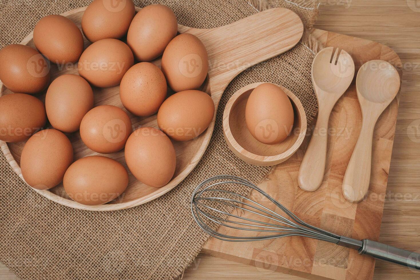 top visie van eieren in houten schotel met houten lepel en vork Aan hout tafel. foto