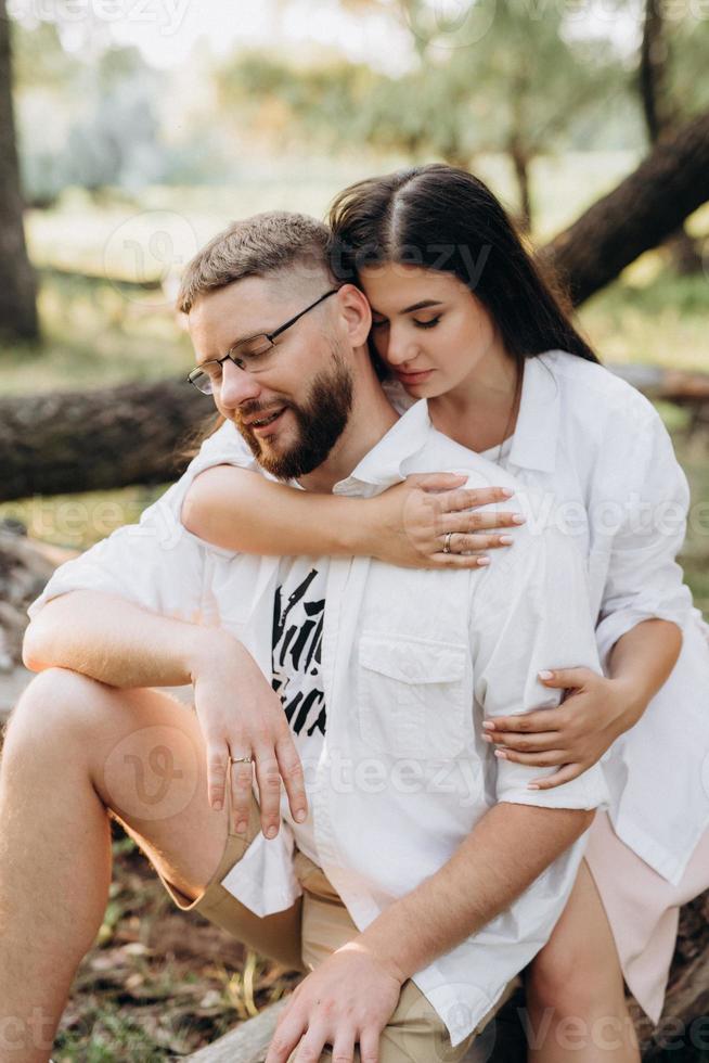 jong stel verliefd op een man met een baard en een meisje met donker haar in lichte kleren foto