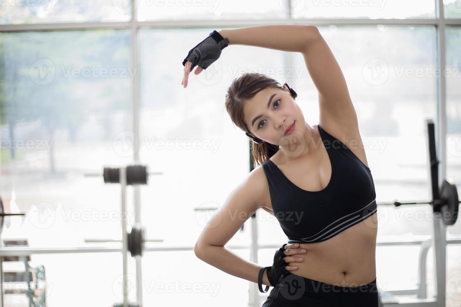 vrouw die zich uitstrekt in de sportschool foto