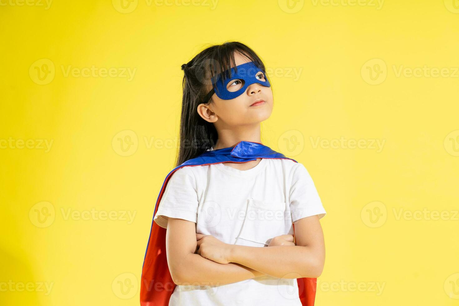 portret van weinig meisje gekleed omhoog net zo een held, geïsoleerd Aan geel achtergrond foto