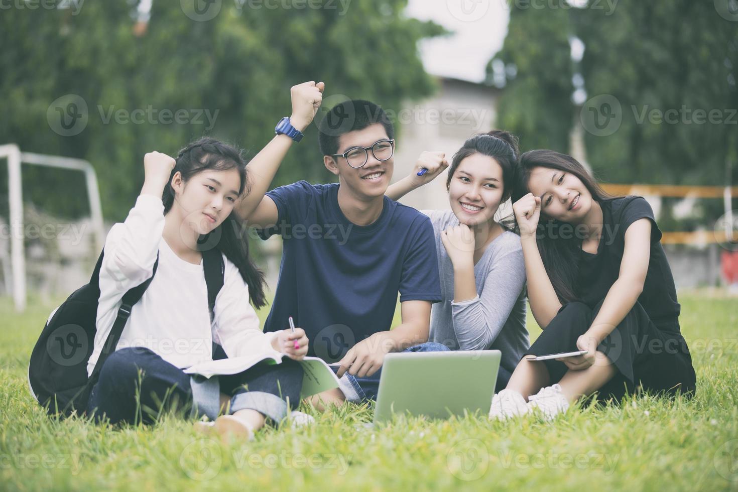 Aziatische studenten juichen op het gazon foto