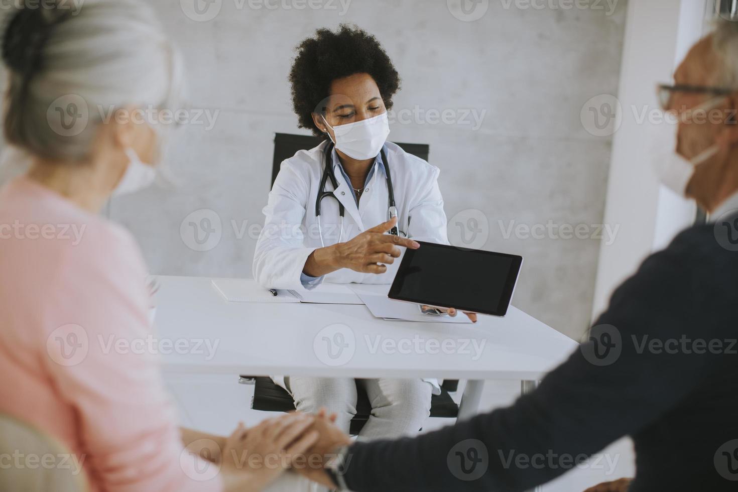 gemaskerd ouder paar dat nieuws van de dokter ontvangt foto