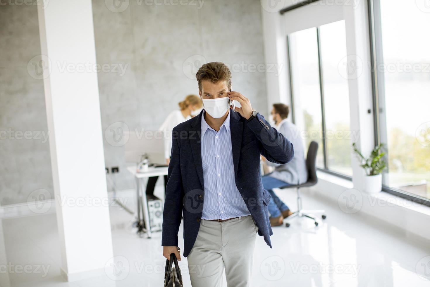 zakenman lopen en telefoon met masker aannemen foto