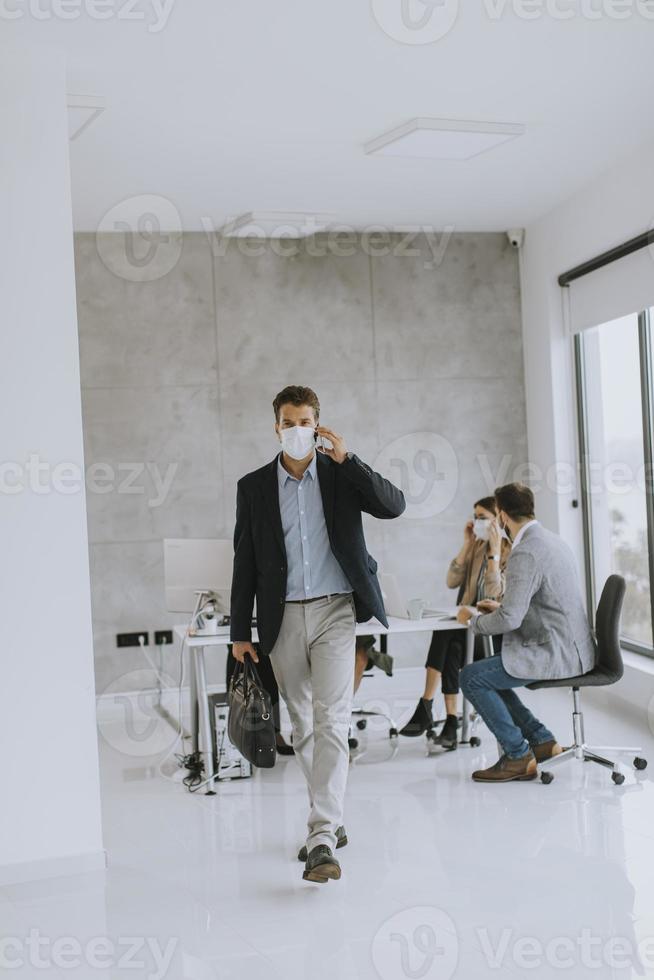 gemaskerde zakenman die de telefoon overneemt en loopt foto