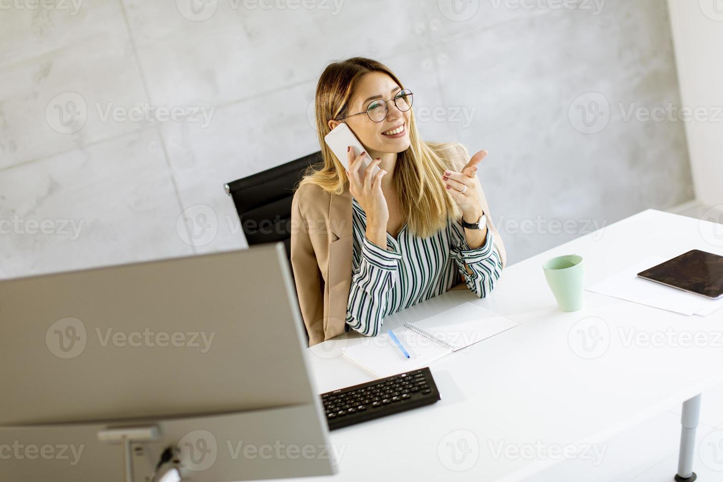 zakenvrouw op telefoon bij bureau foto