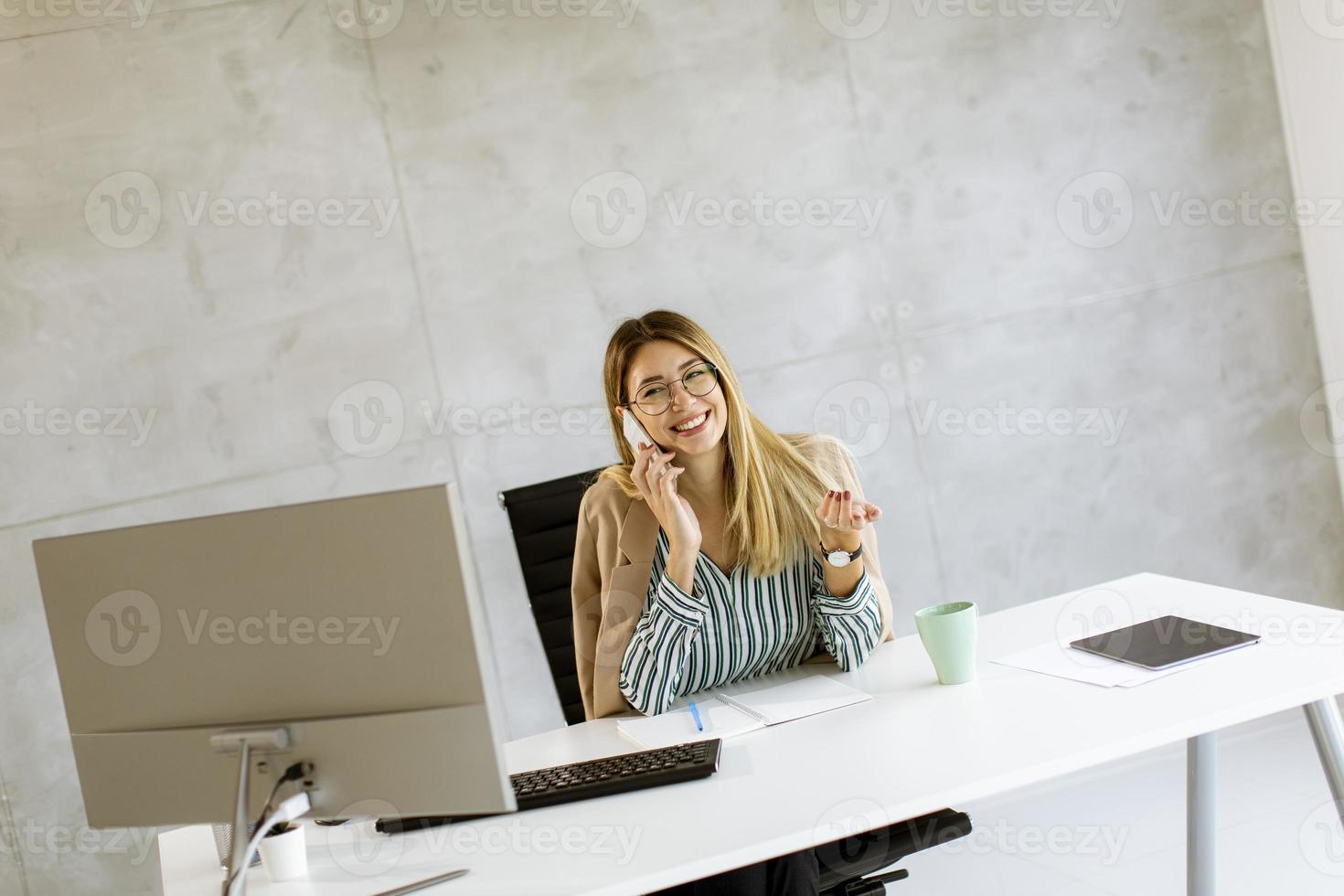 zakenvrouw op telefoon bij bureau met kopie ruimte foto