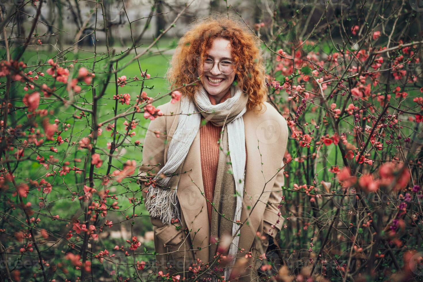 natuurlijk portret van een Kaukasisch gember vrouw met sproeten en gekruld haar. ze is glimlachen en op zoek Bij camera. foto