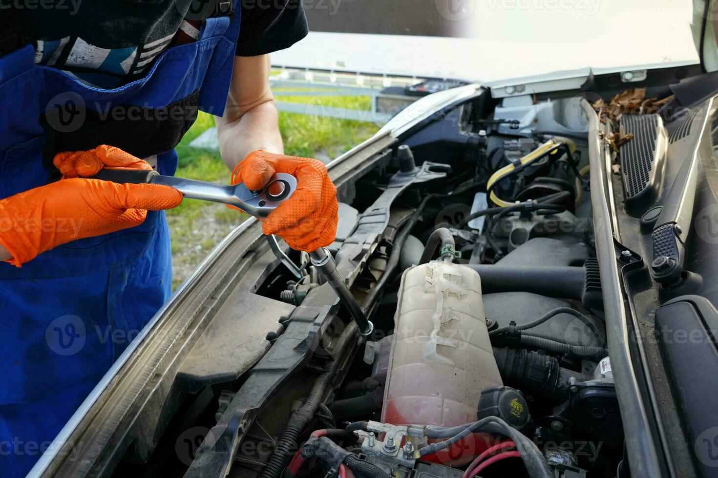 monteur repareren een auto motor. Mens vaststelling gebroken auto. olie veranderen in de auto. auto olie Wijzigen. foto