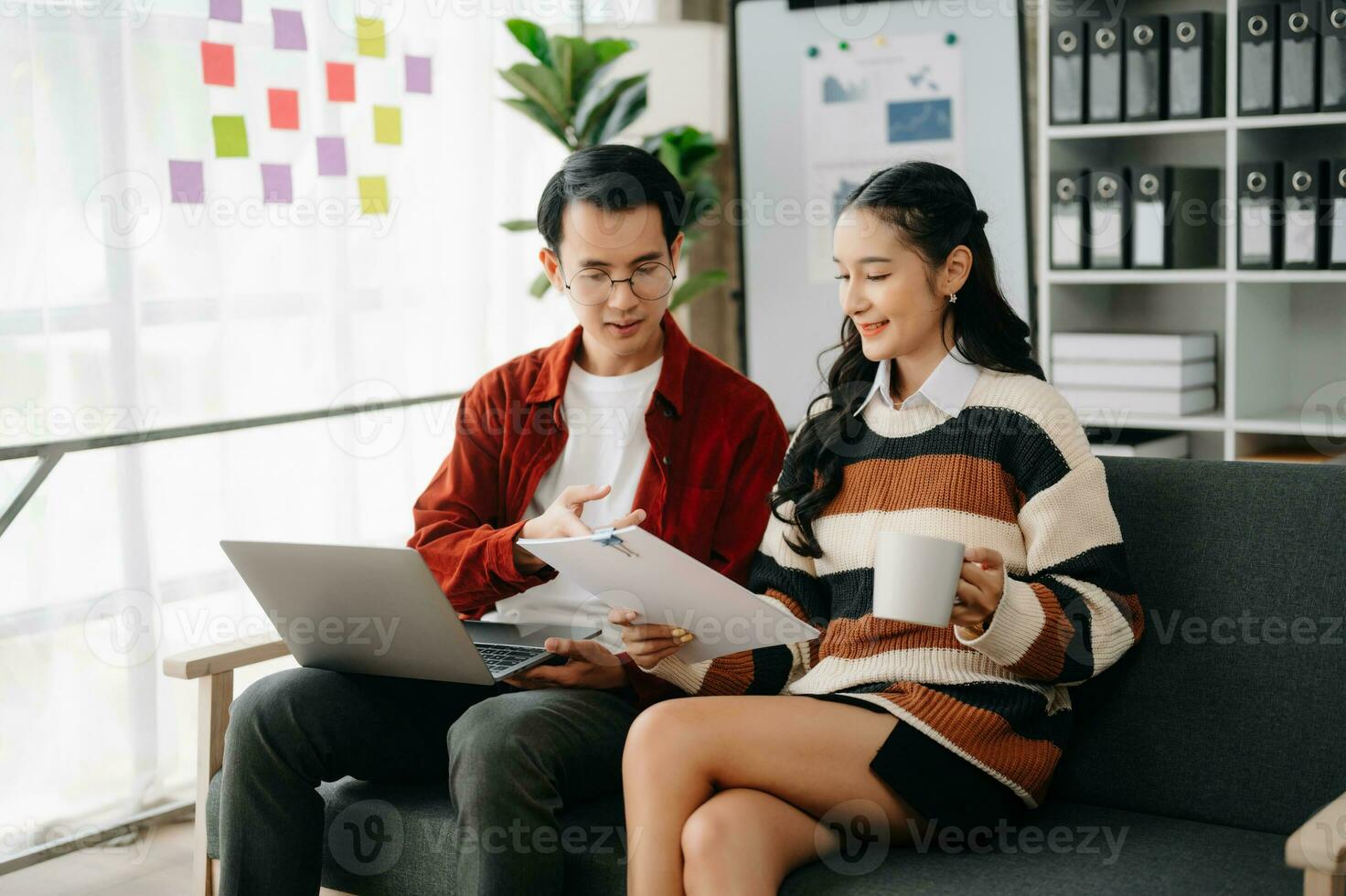 zakenvrouw leidend team vergadering en gebruik makend van tablet en laptop computer met financieel in coworking kantoor foto