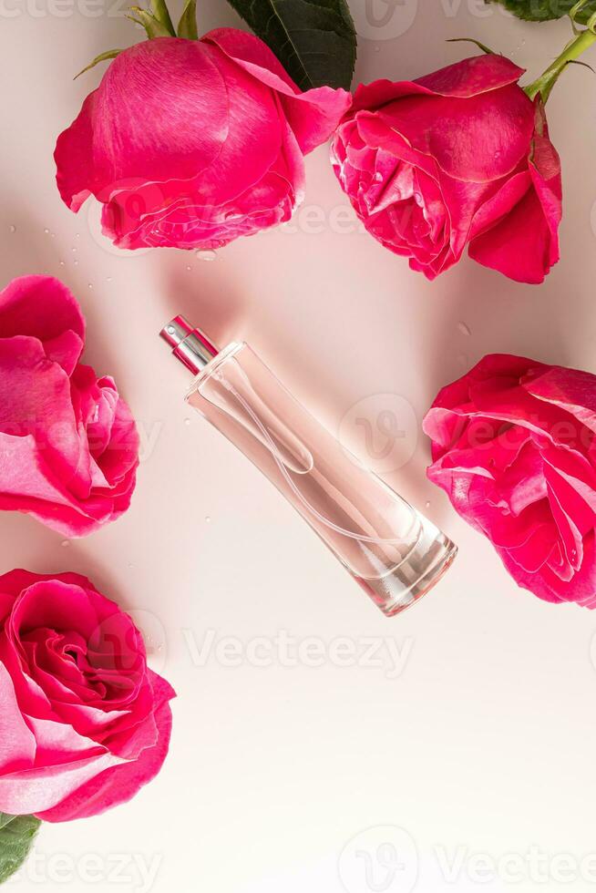 verticaal top visie van een elegant fles van kunstmatig verstuiven of eau de parfum met de geur van delicaat rozen tussen rozen. een kopiëren ruimte. foto