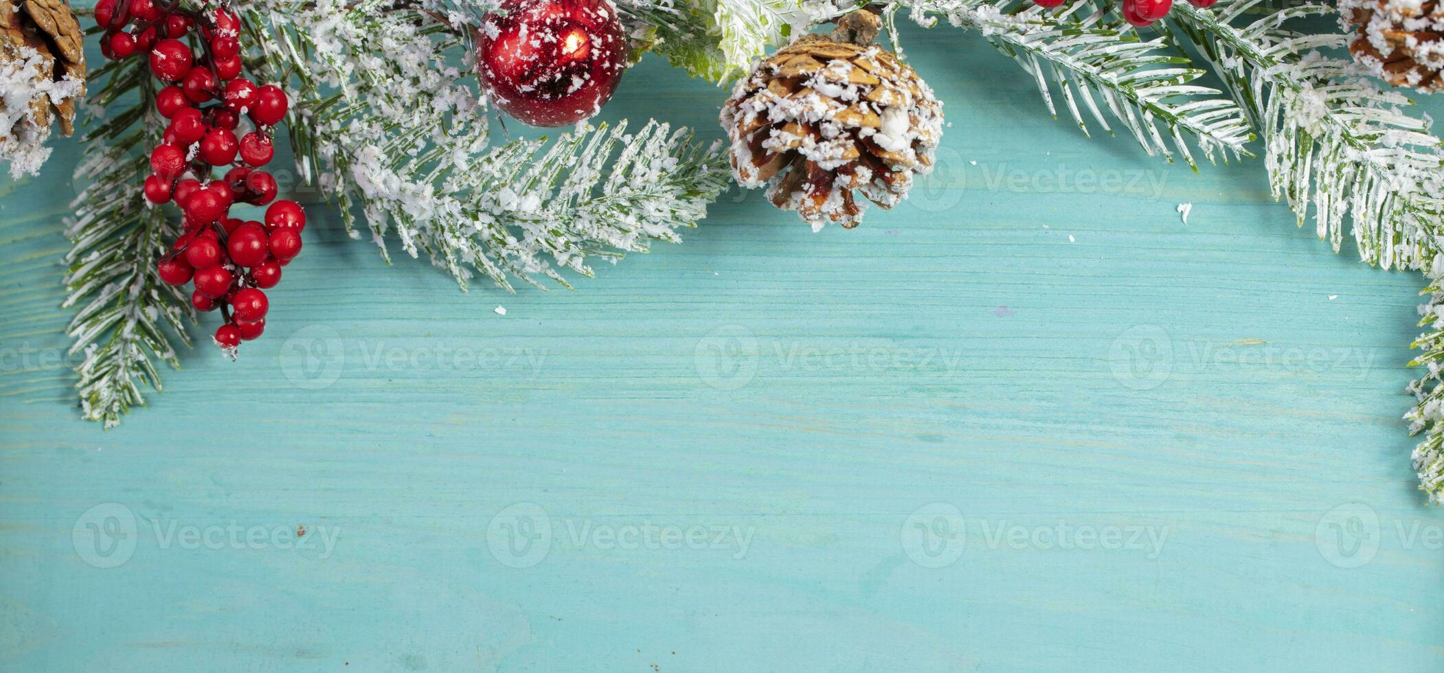 Aan een turkoois hout achtergrond, een decoratie van een net Afdeling en kegels. Kerstmis achtergrond. foto