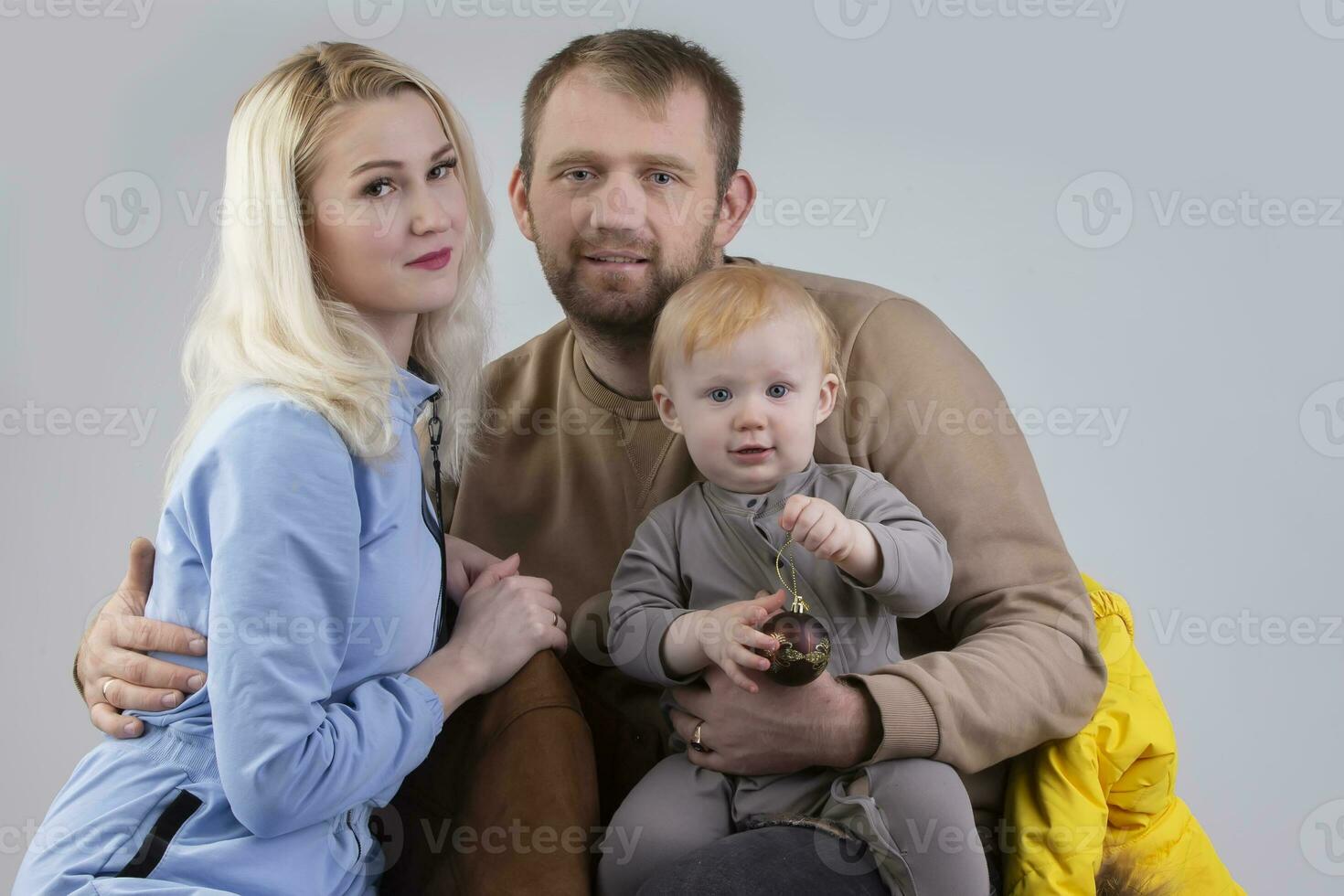 Aan een grijs achtergrond familie van drie mensen mam vader en baby. foto