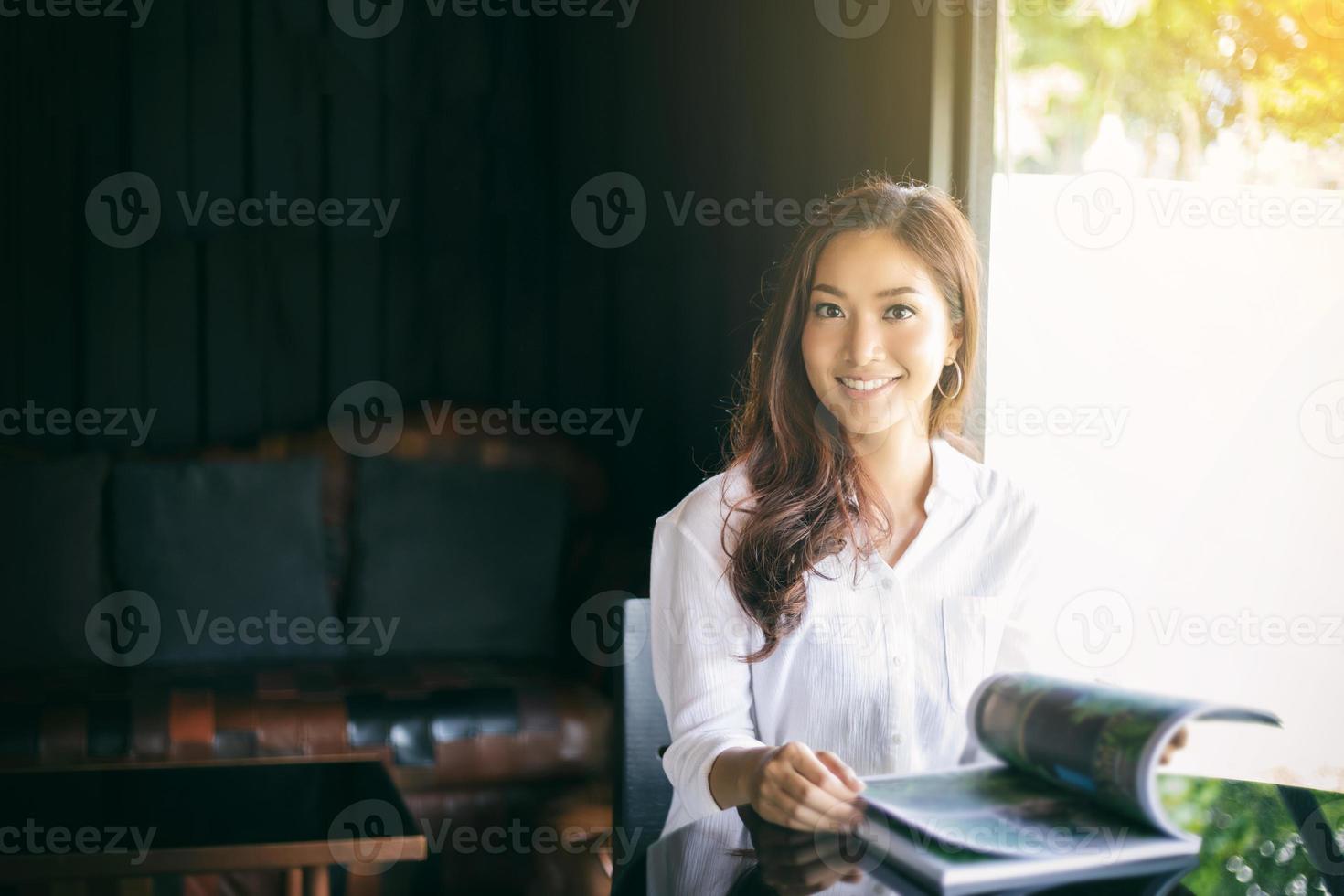 Aziatische vrouwen glimlachen en lezen een boek voor ontspanning in koffiecafé foto