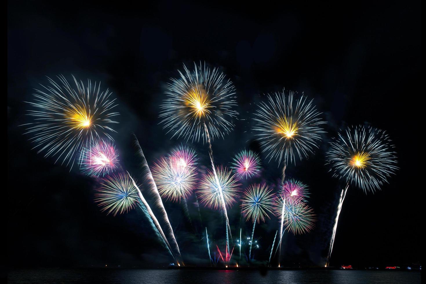 feestelijk mooi kleurrijk vuurwerk op het strand geweldige vakantie vuurwerkfeest of een feestelijke gebeurtenis in de donkere lucht foto