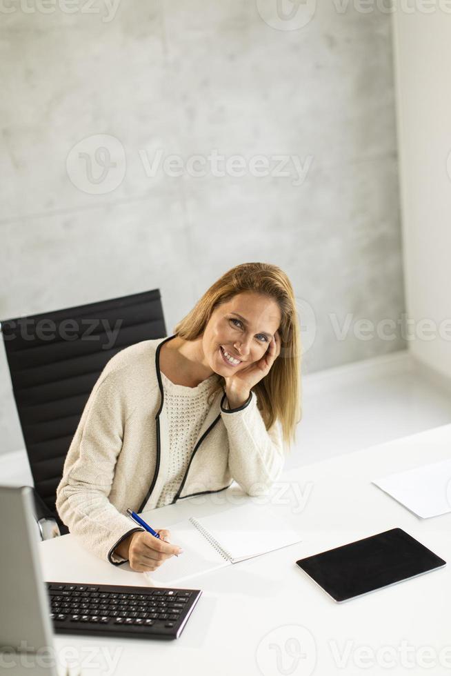 verticale weergave van een zakenvrouw aan bureau met kopie ruimte foto