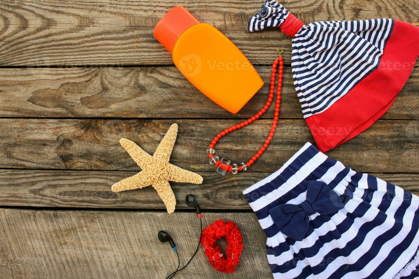 zomer kinderen kleding en strand accessoires voor uw zee vakantie Aan de oud houten achtergrond. afgezwakt afbeelding. foto