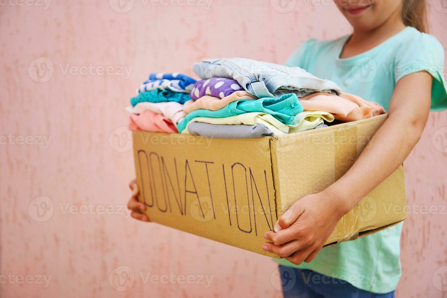 meisje Holding bijdrage doos met met zomer kleren. foto