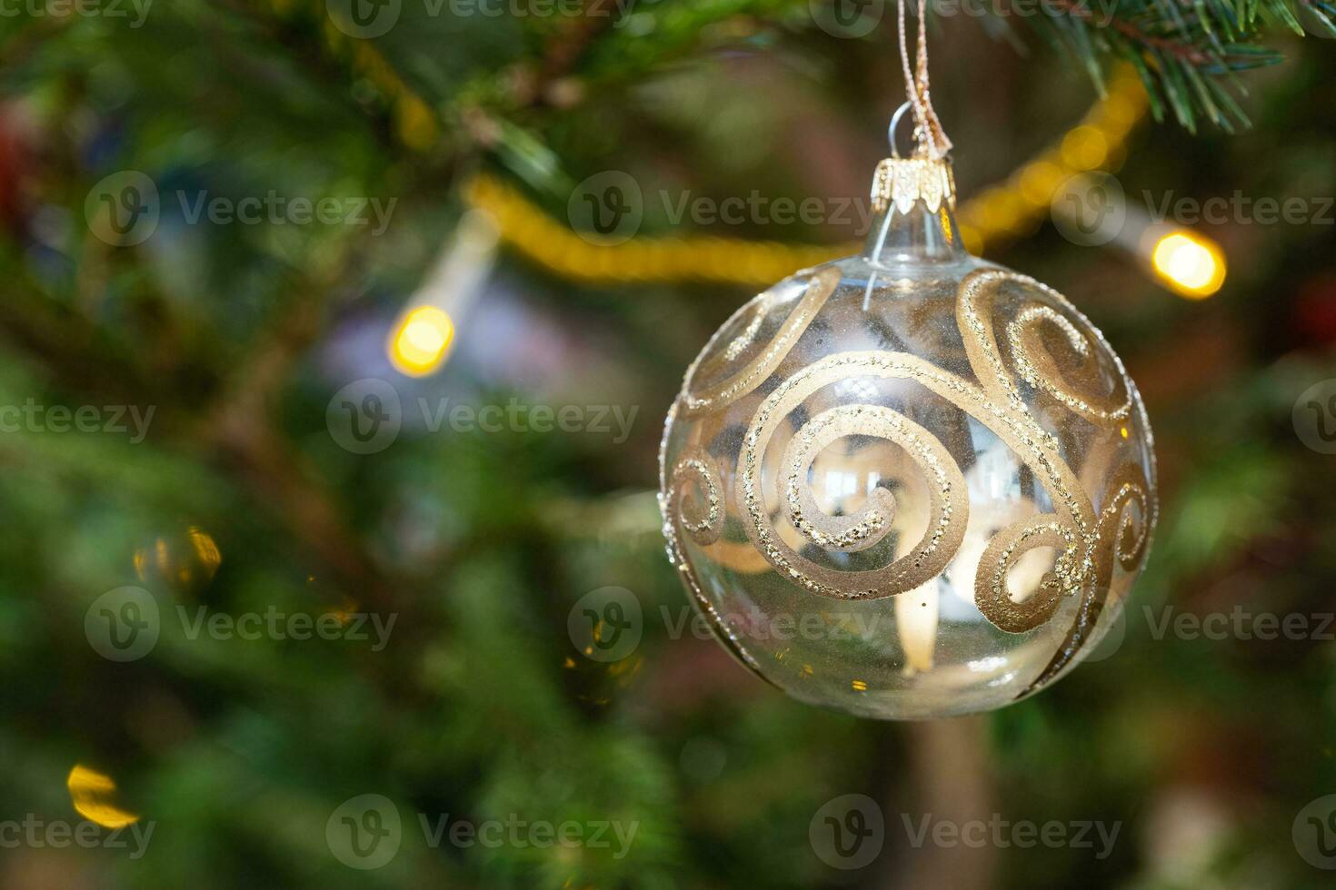 bal versierd met goud patroon Aan Kerstmis boom foto