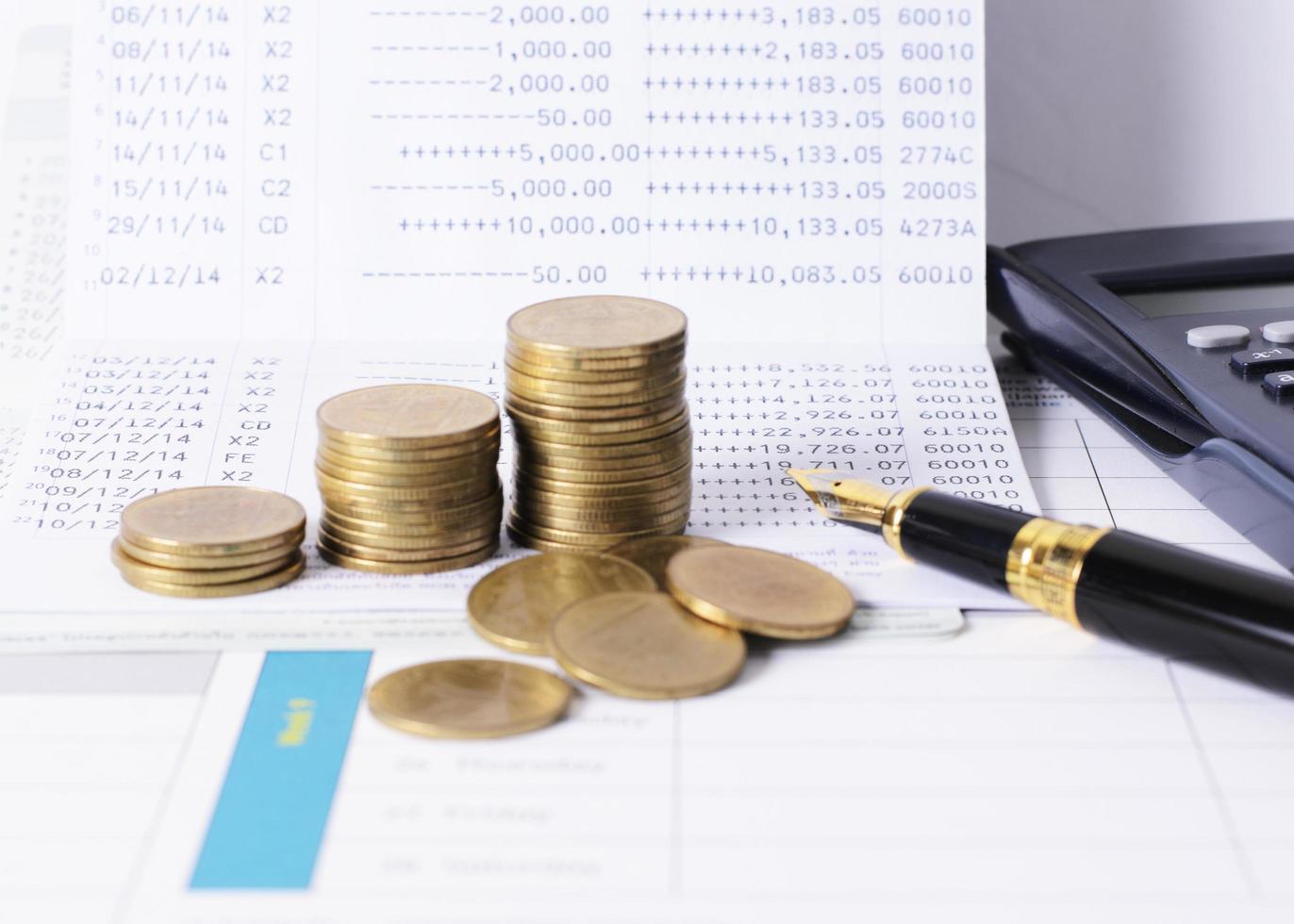 close-up van de vulpen met munten stapel en rekenmachine voor het concept van het geld van de lening foto