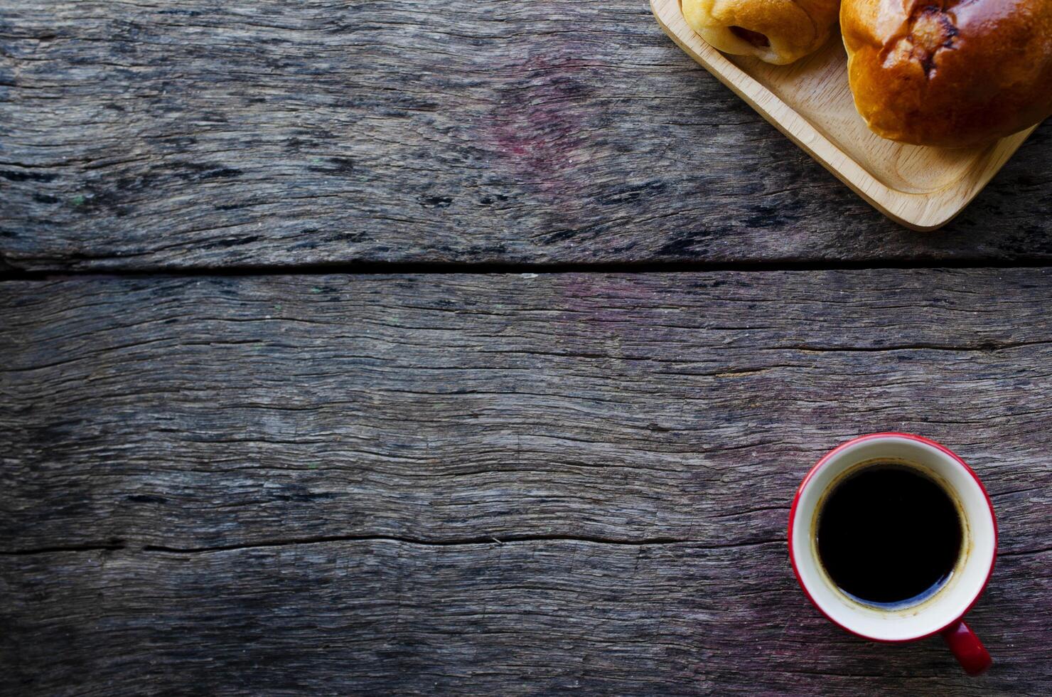 espressokoffie en smakelijke broodjes op houten achtergrond foto