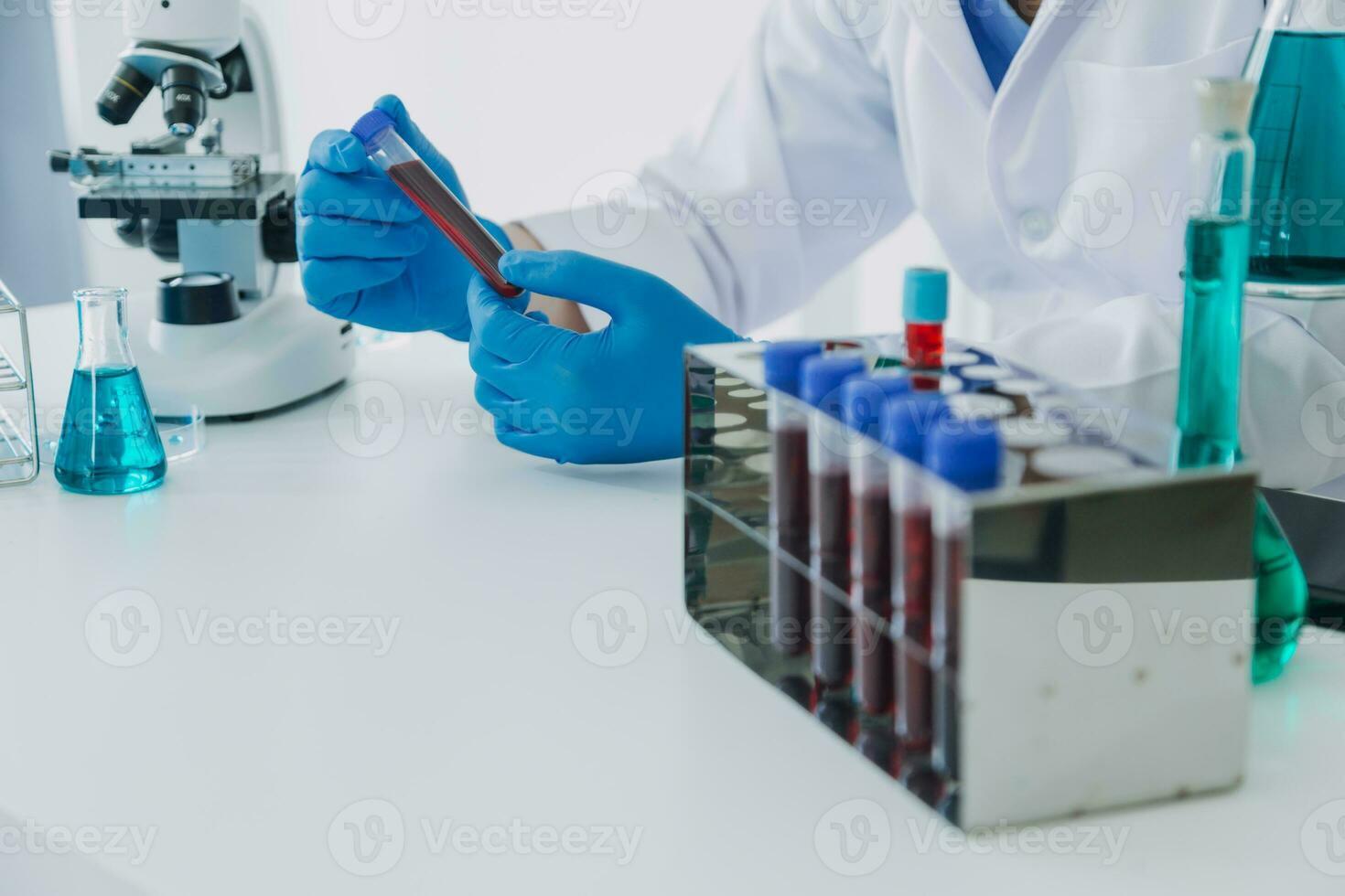 hand- van wetenschapper met test buis en fles in medisch chemie laboratorium blauw banier achtergrond foto