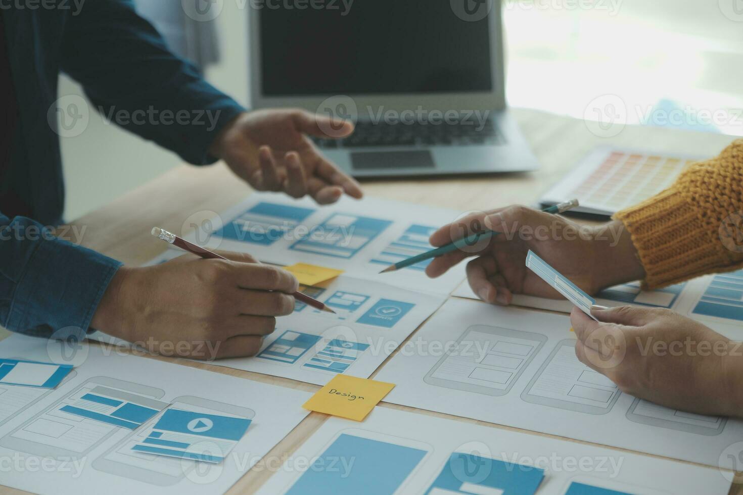 dichtbij omhoog ux ontwikkelaar en ui ontwerper brainstorming over mobiel app koppel wireframe ontwerp Aan tafel met klant breif en kleur code Bij modern kantoor.creatief digitaal ontwikkeling agentschap foto