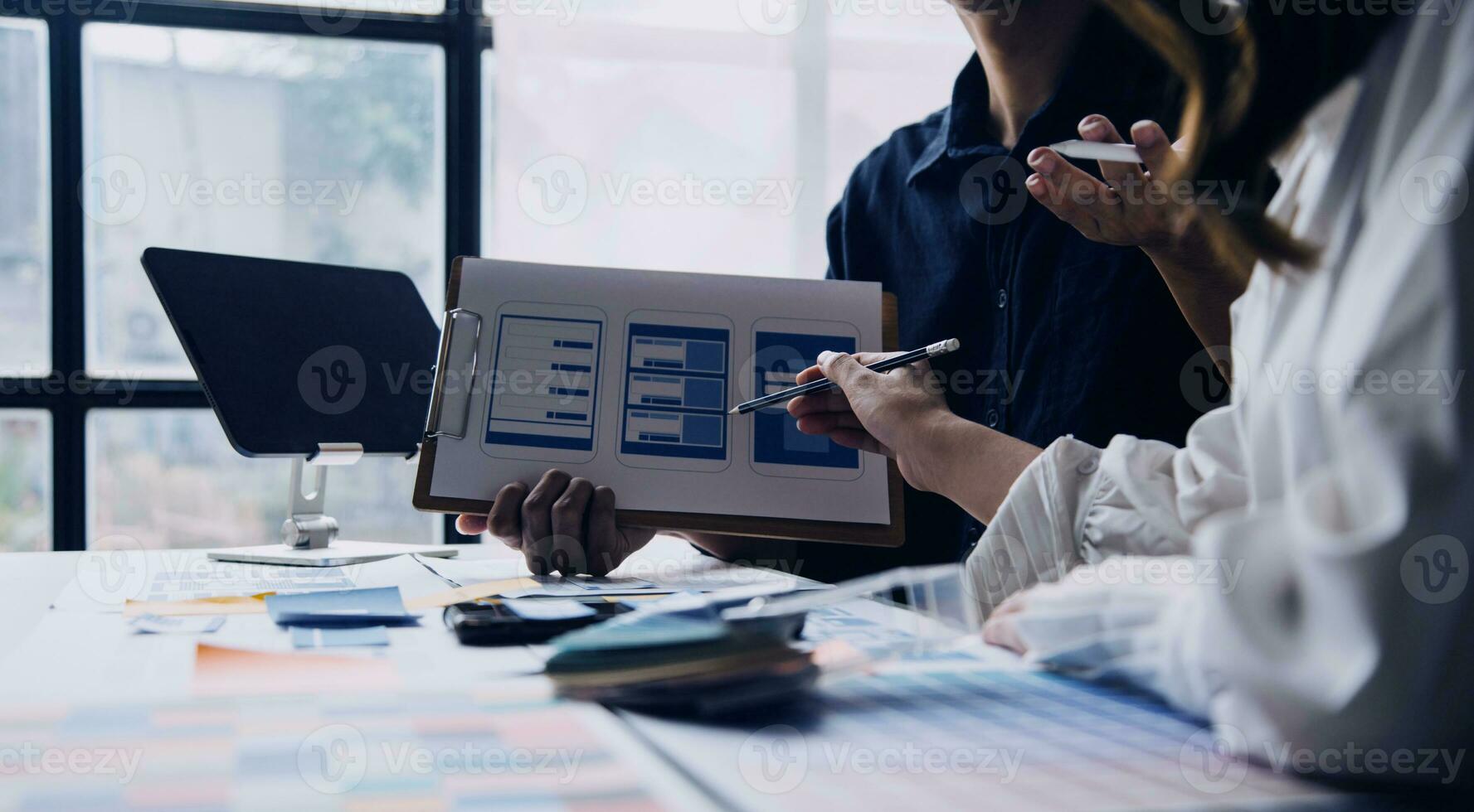 dichtbij omhoog ux ontwikkelaar en ui ontwerper brainstorming over mobiel app koppel wireframe ontwerp Aan tafel met klant breif en kleur code Bij modern kantoor.creatief digitaal ontwikkeling agentschap foto