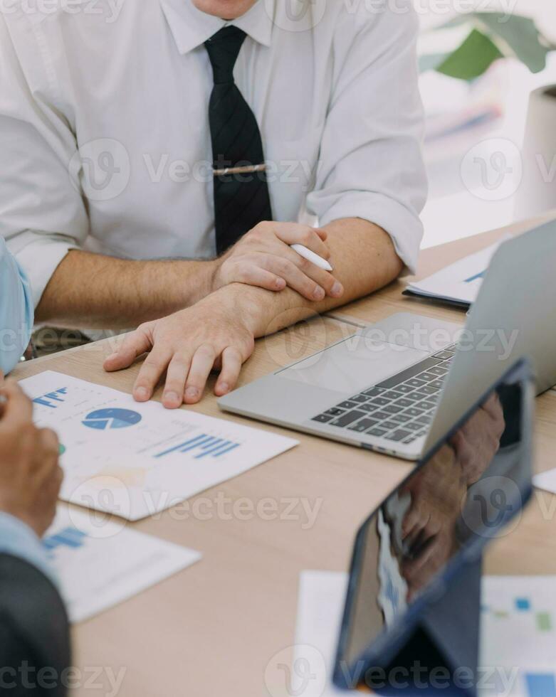 financiële analisten analyseren zakelijke financiële rapporten over een investeringsproject voor digitale tabletplanning tijdens een discussie op een bijeenkomst van bedrijven die de resultaten van hun succesvolle teamwerk laten zien. foto