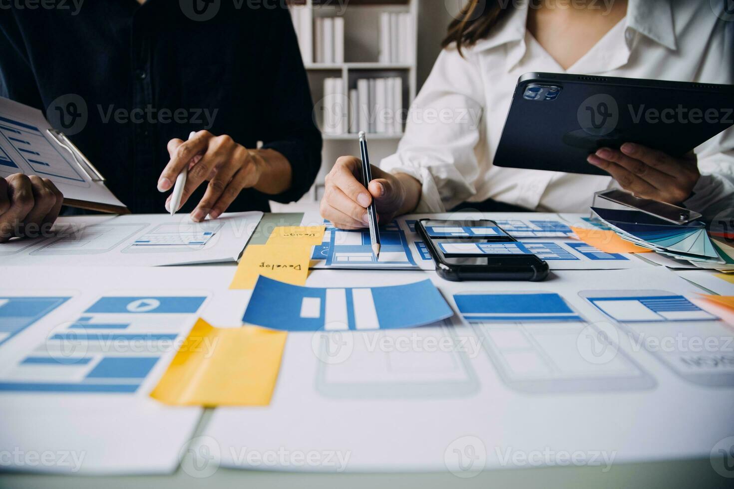 dichtbij omhoog ux ontwikkelaar en ui ontwerper brainstorming over mobiel app koppel wireframe ontwerp Aan tafel met klant breif en kleur code Bij modern kantoor.creatief digitaal ontwikkeling agentschap foto