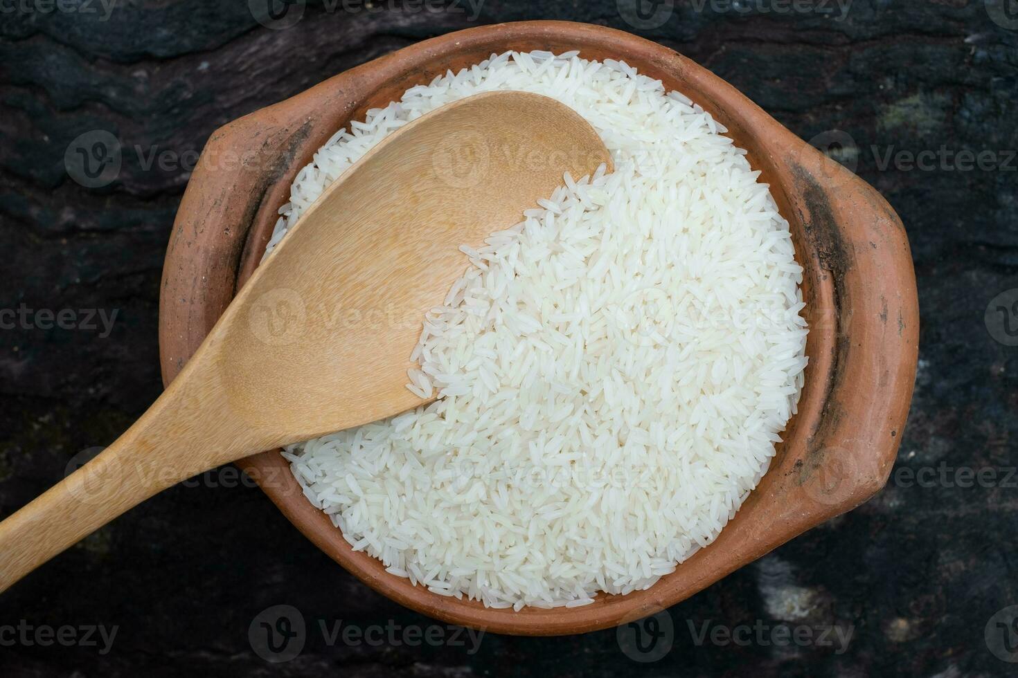 schep rijst met een pollepel in een aarden pot foto