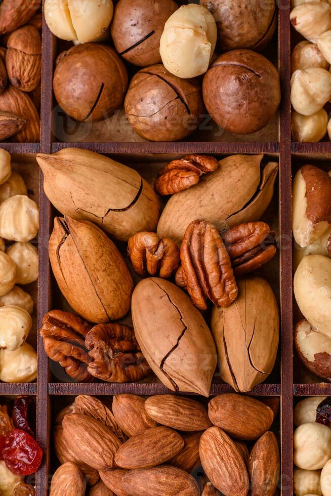 mengen van geroosterd macadamia noten, cashewnoten, pecannoten, amandelen, rozijnen en droog bessen foto