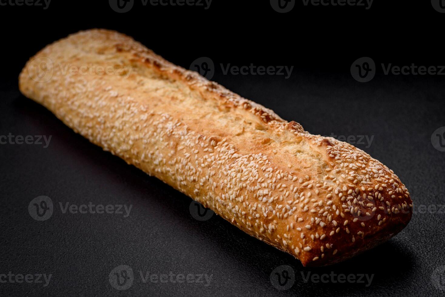 krokant tarwe meel baguette met sesam zaden Aan een houten snijdend bord foto