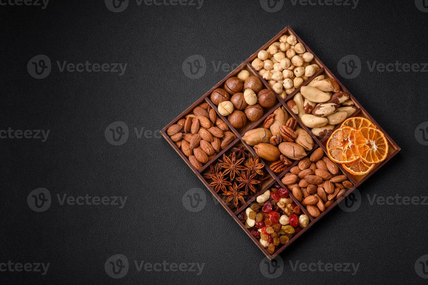 mengen van geroosterd macadamia noten, cashewnoten, pecannoten, amandelen, rozijnen en droog bessen foto